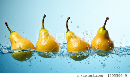 Fresh yellow pears splashing in water against a light blue background during a culinary photoshoot Fresh yellow pears splashing in water against a light blue background during a culinary photoshoot 129559649