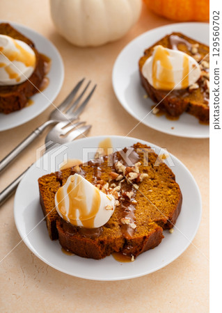 Pumpkin bread freshly baked topped with whipped cream, Thanksgiving dessert Pumpkin bread freshly baked topped with whipped cream, Thanksgiving dessert 129560702