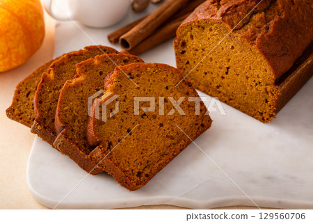 Pumpkin bread freshly baked sliced on a serving board, Thanksgiving dessert Pumpkin bread freshly baked sliced on a serving board, Thanksgiving dessert 129560706
