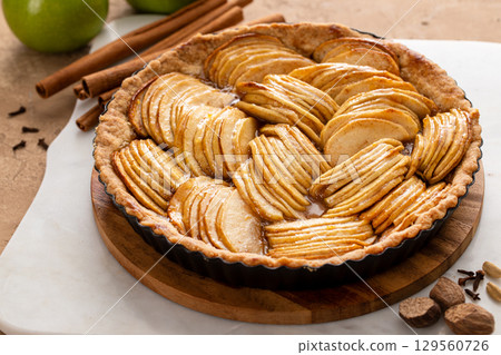 French apple pie or tart with apple slices arranged on top 129560726