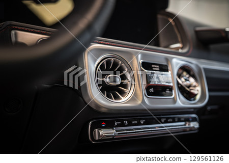 Close up view of the Mercedes AMG G Class dashboard featuring turbine style air vents, digital displays, and red stitched leather trim. Close up view of the Mercedes AMG G Class dashboard featuring turbine style air vents, digital displays, and red stitched leather trim. 129561126