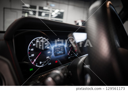 Digital instrument cluster of a Mercedes AMG G Class with speedometer, tachometer, and trip data. Carbon fiber steering wheel partially visible. Digital instrument cluster of a Mercedes AMG G Class with speedometer, tachometer, and trip data. Carbon fiber steering wheel partially visible. 129561173