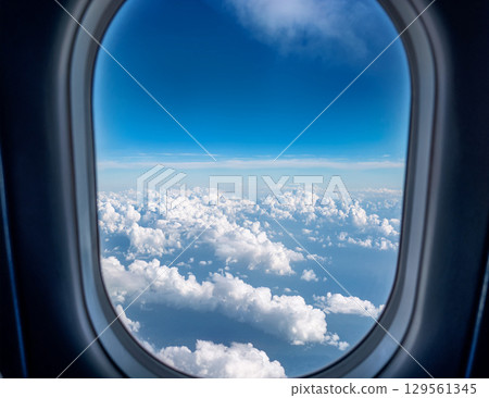 Blue sky and clouds seen from the airplane window Blue sky and clouds seen from the airplane window 129561345