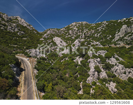 Mountain road across rocky hills of Bozburun peninsula, Turkey under azure sky 129561608