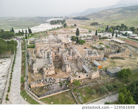 Turkey: Ancient Hierapolis ruins and Pamukkale travertine terraces aerial 129561699
