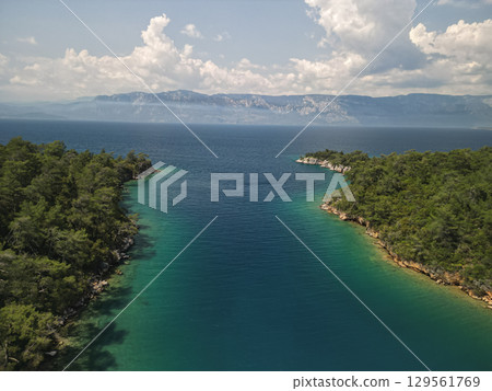 Aerial view narrow channel opening to gokova bay with distant mountains, Turkey 129561769