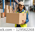 A woman carrying cardboard 129562268