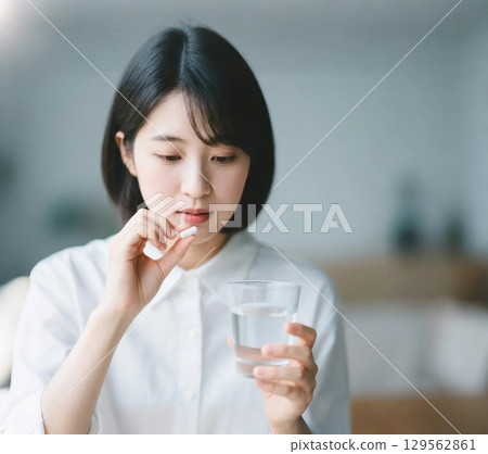 一名日本婦女拿起藥準備服用 129562861
