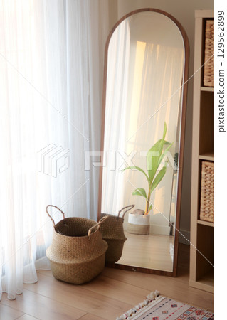 Stylish room featuring a mirror and decorative plants Stylish room featuring a mirror and decorative plants 129562899