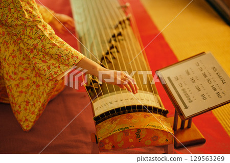 A woman in a kimono playing the koto 129563269