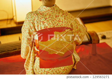 A woman in a kimono playing the koto 129563271