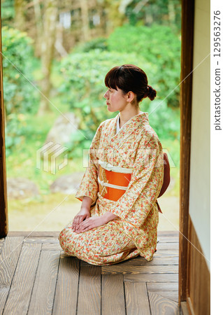 A woman in a kimono quietly standing on the veranda A woman in a kimono quietly standing on the veranda 129563276