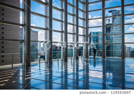 Blue sky reflected in the window of a building 129563697