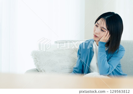 在客廳裡痛苦的年輕女子 129563812