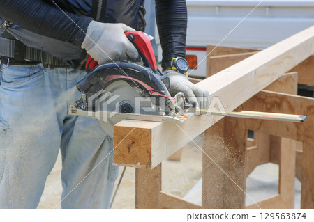 一位木匠正在用圓鋸角尺和圓鋸切割木材。特寫 129563874
