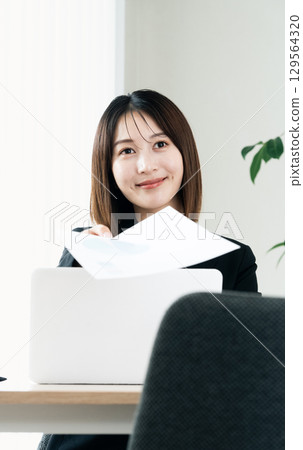 Business woman handing documents Business woman handing documents 129564320