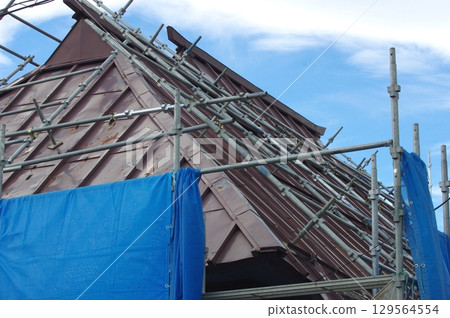 為舊房子的鋼屋頂重新粉刷的鷹架 為舊房子的鋼屋頂重新粉刷的鷹架 129564554