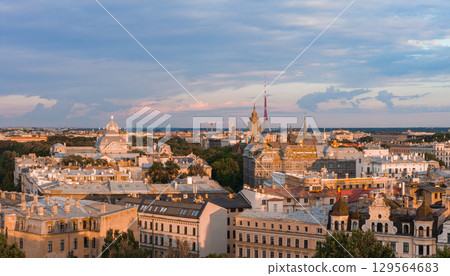 Riga, Latvia at sunset featuring the Riga TV Tower, Jugendstil architecture, and the Nativity of Christ Cathedral amidst greenery under a serene sky. 129564683