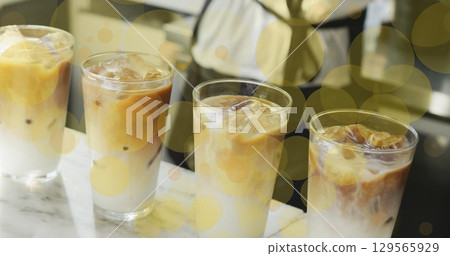 Image of falling yellow dots over ice coffee 129565929