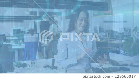 Image of financial data and graphs over asisan woman using tablet in office Image of financial data and graphs over asisan woman using tablet in office 129566017