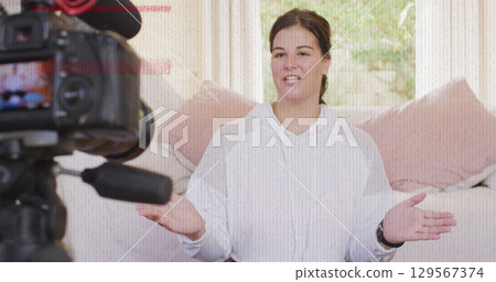 Image of interference over caucasian woman making vlog using camera Image of interference over caucasian woman making vlog using camera 129567374