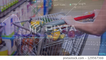 Shopper wearing T-shirt loading cart with pineapple and greens in store aisle, digital overlay 129567388