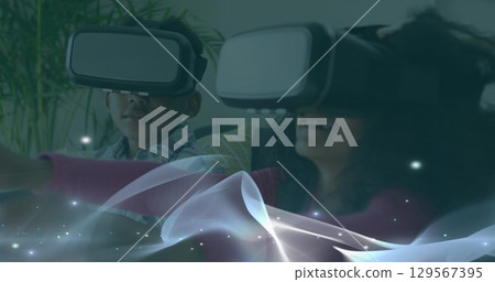 Image of waves over african american boy and girl in vr headset Image of waves over african american boy and girl in vr headset 129567395