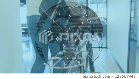 Walking three colleagues guiding bicycle with rack in office corridor, with digital globe overlay 129567442