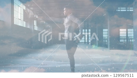 Image of clouds over african american sportsman stretching 129567511