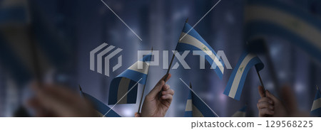 Nicaragua flags in their hands on a blurred urban background 129568225