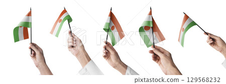 The Niger flag in hand in different angles on a white background The Niger flag in hand in different angles on a white background 129568232