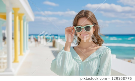 Woman posing in sunglasses on the beach in summer 129568776