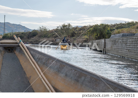 Hozugawa River Boat Ride, Calm waters with a boat navigating a serene landscape. 129569918
