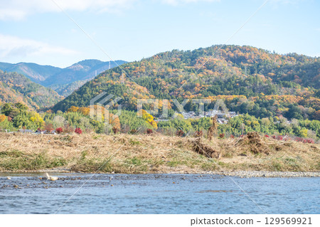 Scenic river with autumn foliage and hills. at Hozugawa River 129569921