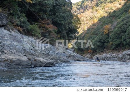 Serene river flowing between rocky banks at Hozugawa River 129569947