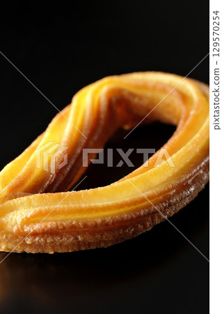 Churros photographed against a black background 129570254