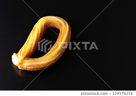 Churros photographed against a black background 129570258