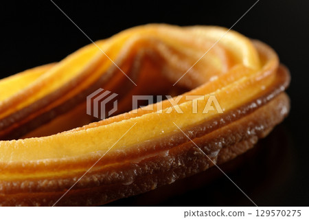 Churros photographed against a black background 129570275
