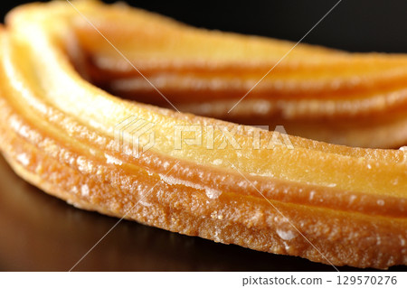 Churros photographed against a black background 129570276