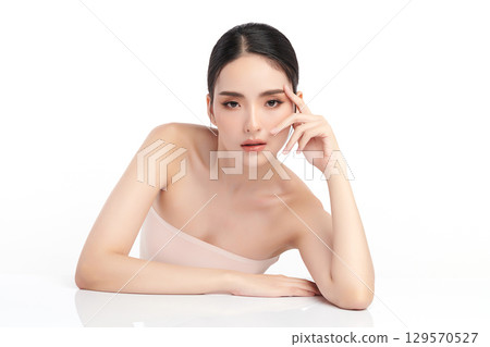 A beautiful young Asian woman with clean, fresh skin against a white background. Skincare, facial treatment, cosmetology, beauty, and spa. An elegant portrait of an Asian woman. A beautiful young Asian woman with clean, fresh skin against a white background. Skincare, facial treatment, cosmetology, beauty, and spa. An elegant portrait of an Asian woman. 129570527