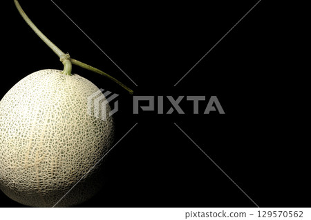 A whole melon photographed against a black background 129570562