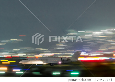Plane taxiing on the runway at night 129570771