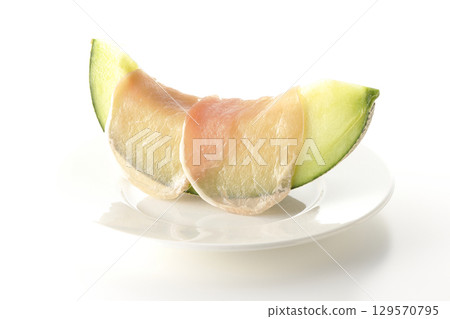 Raw ham and melon photographed on a white background 129570795