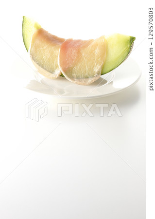 Raw ham and melon photographed on a white background 129570803