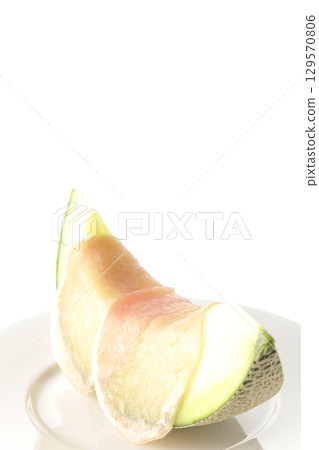 Raw ham and melon photographed on a white background 129570806