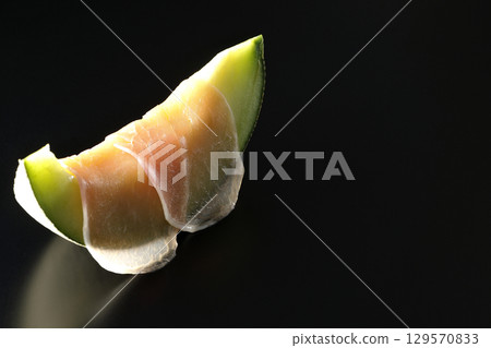 黑色背景下拍攝的生火腿和甜瓜 黑色背景下拍攝的生火腿和甜瓜 129570833