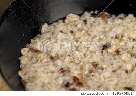 porridge with fruits in a bowl , cooking instant oatmeal porridge, close up 129570991