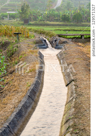 Irrigation canal in a rural agricultural landscape 129571327