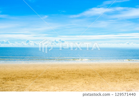 Serene beach with clear blue sky and calm waters 129571440