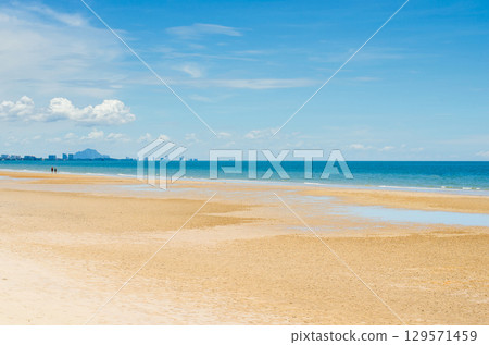 Sunny beach with clear skies and calm waters. 129571459